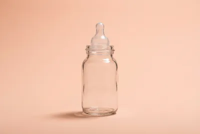 Gros plan iconique d'un biberon sur fond épuré.