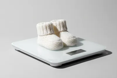 Chaussons de bébé sur un pèse-personne moderne